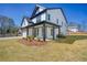 Side view of this two-story home with a covered front porch, showcasing the landscaping and architectural details at 1064 Eastview Ne Rd, Conyers, GA 30012