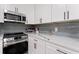 Close up of kitchen featuring stainless steel appliances, subway tile backsplash and quartz countertops at 203 Sunset Nw Ave, Atlanta, GA 30314