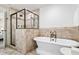 Bathroom featuring a stand-alone tub, tiled shower and travertine tile surround at 3641 Broughton Se Cir, Atlanta, GA 30339