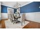 Dining room featuring modern light fixture, blue accent wall and hardwood floors at 3641 Broughton Se Cir, Atlanta, GA 30339