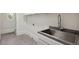 Functional laundry room with a stainless steel sink, gray countertops, and a round window at 725 Riley Pl, Sandy Springs, GA 30327