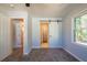 Bedroom with sliding barn door to bathroom and closet; neutral carpeting and natural light at 228 W Simon Nw Ter, Atlanta, GA 30318