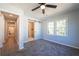 Bright bedroom featuring plush carpeting, a ceiling fan, and a bathroom with sliding barn door at 228 W Simon Nw Ter, Atlanta, GA 30318
