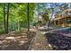 Picturesque backyard with a stone walkway, mature trees, multi-level deck, and lush landscaping at 1585 Lazy River Ln, Sandy Springs, GA 30350