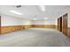 Expansive basement with wood paneled walls, carpeted floors and multiple doors at 1585 Lazy River Ln, Sandy Springs, GA 30350