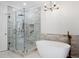 Elegant bathroom with a glass-enclosed shower and a freestanding tub with decorative brick tiling at 1585 Lazy River Ln, Sandy Springs, GA 30350