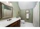 Cozy bathroom with vintage vanity, a framed mirror and white hexagon tile flooring at 1585 Lazy River Ln, Sandy Springs, GA 30350