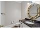 Elegant powder room with decorative mirror, granite countertop and tiled floor at 1585 Lazy River Ln, Sandy Springs, GA 30350