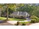 Gorgeous home featuring mature landscaping, attached garage, and classic architectural details, sitting on a private lot at 1585 Lazy River Ln, Sandy Springs, GA 30350