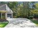 Spacious driveway leading to the garage of a brick home, surrounded by mature trees and well-maintained landscaping at 1585 Lazy River Ln, Sandy Springs, GA 30350