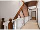 Hallway featuring wooden beams, white railings, and neutral carpeting leading to additional living spaces at 1585 Lazy River Ln, Sandy Springs, GA 30350