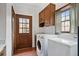 Laundry room with a washer, dryer, window, access to the exterior, and cabinet storage at 1585 Lazy River Ln, Sandy Springs, GA 30350