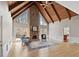 Spacious living room featuring vaulted ceilings, exposed wood beams, stone fireplace, and large windows at 1585 Lazy River Ln, Sandy Springs, GA 30350