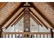 Grand living room showcases exposed wooden beams, stone fireplace, and view of the backyard at 1585 Lazy River Ln, Sandy Springs, GA 30350