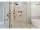 Elegant walk-in shower with grey and white brick tiling, clear glass door, and bronze fixtures at 1585 Lazy River Ln, Sandy Springs, GA 30350