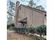 Angle view of the exterior with mature landscaping and a chimney at 43 Willowick Ct, Stonecrest, GA 30038