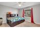 Bright bedroom with an area rug, window, red curtains, and a stylish platform bed with storage drawers at 75 Price W Dr, Locust Grove, GA 30248