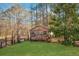 Wood storage shed in backyard with windows and double doors, surrounded by lush greenery at 75 Price W Dr, Locust Grove, GA 30248