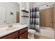 Cozy bathroom featuring a vanity, toilet, shower with tub, and shelving for storage of towels and toiletries at 2445 Westlington Cir, Cumming, GA 30040