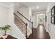 Elegant home entryway with a hardwood floor, staircase with wrought iron spindles, and bright, neutral wall paint at 2445 Westlington Cir, Cumming, GA 30040