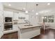 A bright kitchen featuring white cabinets, granite countertops, a central island, and stainless steel appliances at 2445 Westlington Cir, Cumming, GA 30040