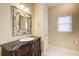 Bathroom vanity with a marble countertop, white bowl sink, decorative mirror, and window at 589 Cook Dr, Ellenwood, GA 30294