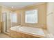 A bathroom featuring a jetted tub and separate shower with a neutral color scheme at 589 Cook Dr, Ellenwood, GA 30294