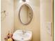 Half-bathroom featuring an oval mirror above the pedestal sink, decorated with flowers at 589 Cook Dr, Ellenwood, GA 30294