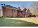 Back view of brick house with a spacious backyard and covered patio at 589 Cook Dr, Ellenwood, GA 30294