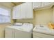 Laundry room with white washer and dryer, sink, and ample cabinet storage space at 589 Cook Dr, Ellenwood, GA 30294