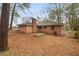 A full view of the brick house and backyard surrounded by trees at 1678 Capistrana Pl, Decatur, GA 30032