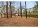 Large backyard view showing the brick house surrounded by mature trees at 1678 Capistrana Pl, Decatur, GA 30032