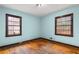 A bedroom with wood floors and two windows with dark trim at 1678 Capistrana Pl, Decatur, GA 30032