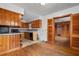 An older kitchen features wood cabinets and a breakfast bar open to an adjacent room at 1678 Capistrana Pl, Decatur, GA 30032