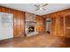 Living room with paneled walls, wood floors, a brick fireplace, and a ceiling fan at 1678 Capistrana Pl, Decatur, GA 30032