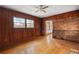 Living room with paneled walls, wood floors, and a brick fireplace at 1678 Capistrana Pl, Decatur, GA 30032