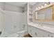 Bathroom featuring white tile, white vanity with gold hardware, and an elegant mirror at 2142 Graystone Pkwy, Grayson, GA 30017