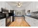 Modern kitchen with stainless steel appliances, white cabinets, granite countertops, and hardwood floors at 2142 Graystone Pkwy, Grayson, GA 30017