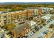 An aerial view showcases a lively mixed-use community with apartments, retail shops, and outdoor dining at 2601 Boulder Way, Woodstock, GA 30188