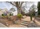 Inviting Oak Park entrance featuring large rocks, a natural landscape, and a view of a charming white home at 2601 Boulder Way, Woodstock, GA 30188