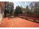 Exterior back deck shot showing a stained red deck, wooden bench, and green trees at 541 Exam Ct, Lawrenceville, GA 30044