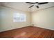 Spacious bedroom featuring hardwood floors, large window, and ceiling fan at 541 Exam Ct, Lawrenceville, GA 30044