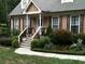 Inviting front porch with landscaped garden, decorative flower bed and stairs leading up to front door at 1765 Round Rd, Grayson, GA 30017