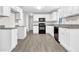 Modern kitchen featuring white cabinets, granite countertops, black appliances, and durable laminate flooring at 1765 Round Rd, Grayson, GA 30017