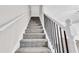 Carpeted staircase with white walls and black handrail at 1765 Round Rd, Grayson, GA 30017