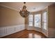 Elegant dining room featuring hardwood floors, wainscoting, modern light fixture, and large windows at 3028 Hallman Cir, Marietta, GA 30064