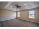 Spacious primary bedroom featuring tray ceilings, ceiling fan and plush carpet at 3028 Hallman Cir, Marietta, GA 30064