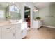 Bright bathroom features dual sinks with white cabinetry, tile floor, and window at 480 Shore Drive, Suwanee, GA 30024