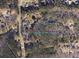 An aerial view showing a treed lot outlined in blue, surrounded by sparse residences at 2228 Christian Cir, Conyers, GA 30013