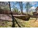 Backyard with a wooden retaining wall, grass, and trees at 29 Cliftwood Dr, Sandy Springs, GA 30328